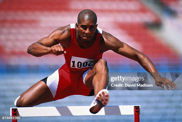 track and field, runner jumping over hurdle - hurdling track event 個照片及圖片檔