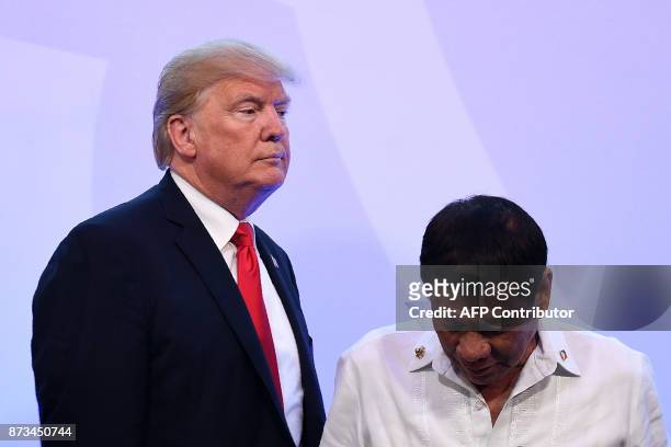 President Donald Trump walks past Philippine President Rodrigo Duterte after posing for a family photo during the ASEAN-US 40th Anniversary...