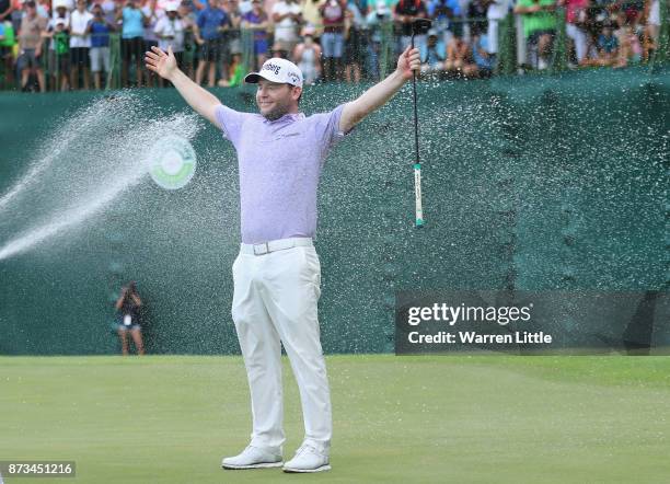 Branden Grace of South Africa is sprayed with champagne by Louis Oosthuizen and Darren Fichardt of South Africa after winning the Nedbank Golf...