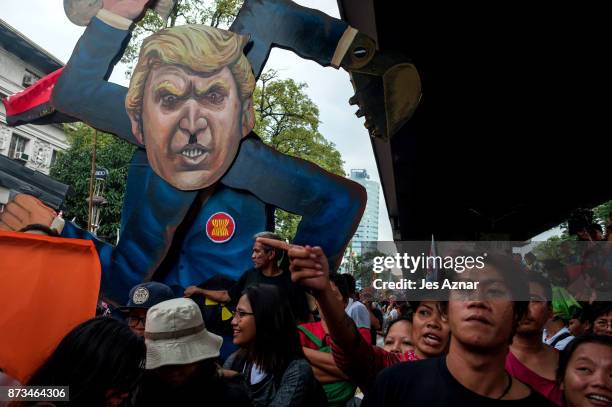 Protesters clash with riot police as they march the streets of Manila during the start of the ASEAN meetings between heads of state on November 13,...