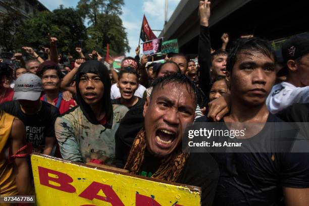 Protesters clash with riot police as they march the streets of Manila during the start of the ASEAN meetings between heads of state on November 13,...