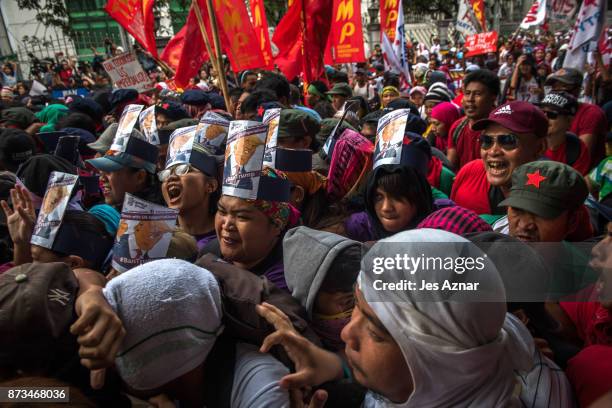 Protesters clash with riot police as they march the streets of Manila during the start of the ASEAN meetings between heads of state on November 13,...