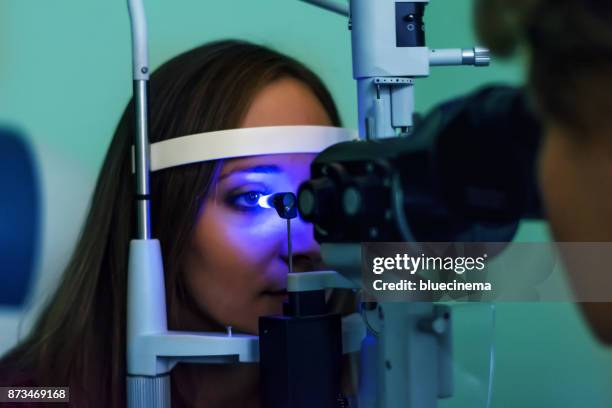 young woman undergoing eye examination - pressão física imagens e fotografias de stock