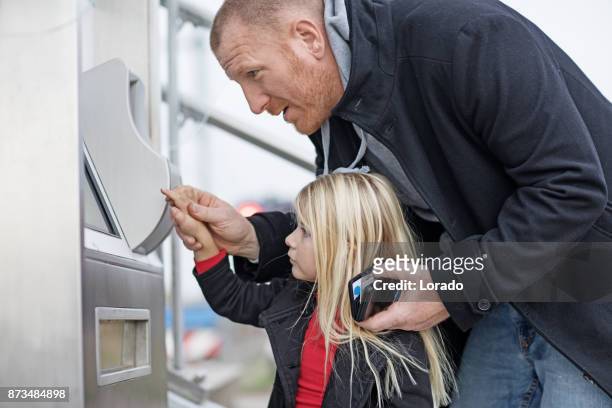 handsome redhead middle aged father and cute blonde daughter traveling on public transport - near field communication stock pictures, royalty-free photos & images
