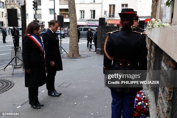 French President Emmanuel Macron and Paris Mayor Anne Hidalgo attend a minute of silence after they laid a wreath of flowers in front of a...