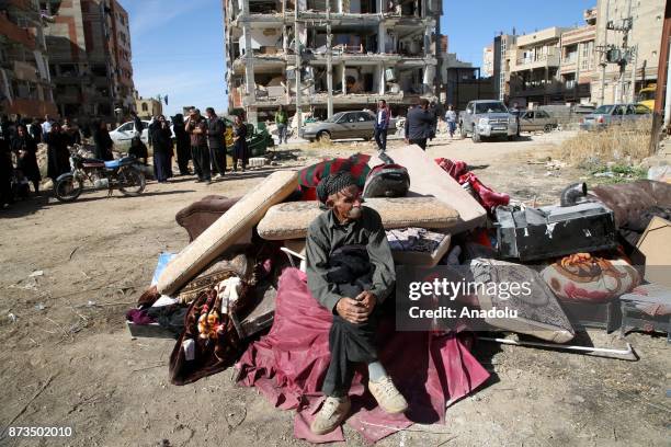 An earthquake survivor elderly man wait with his belongings at the outside of the damaged buildings in Sarpol-e Zahab town of Kermanshah, Iran on...