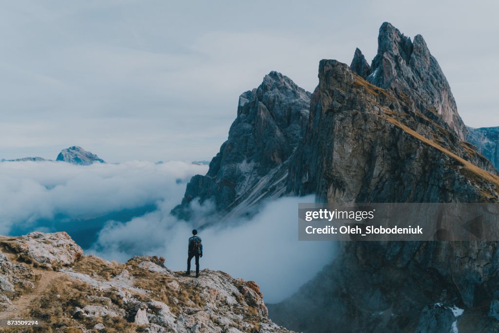 Hombre caminar cerca de la montaña de Seceda en Dolomitas