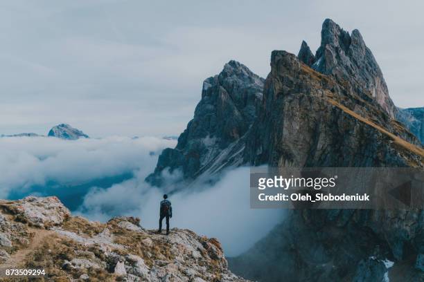 uomo che escursioni vicino al monte seceda nelle dolomiti - montagna foto e immagini stock