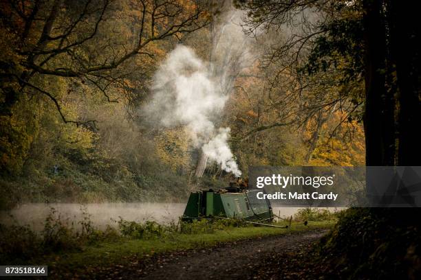 Smoke from a wood burner rises from a narrowboat moored on the Kennet and Avon canal near the Dundas Aqueduct as the sun rises on November 13, 2017...