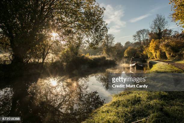 The autumn colours are reflected in the water of the Kennet and Avon canal near Limpley Stoke as the sun rises on November 13, 2017 near Bath,...