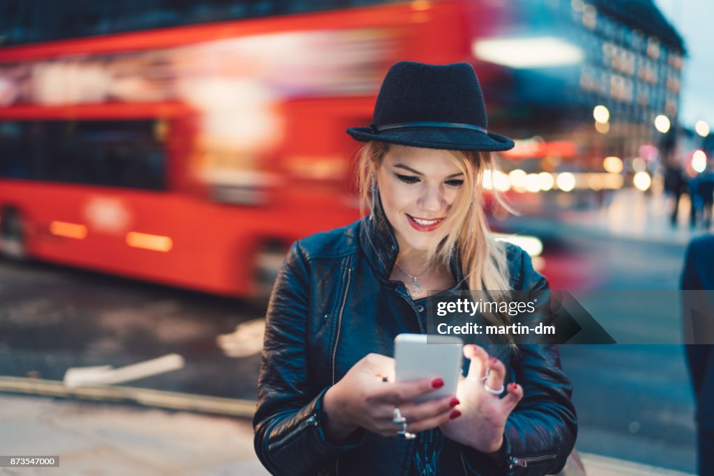 Cute girl in London using smartphone
