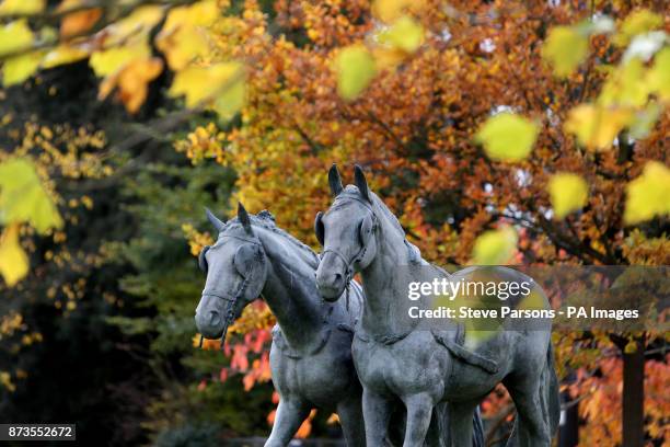 Statue of two Windsor Greys, Daniel and Storm, who draw the royal carriages on state occasions, stand out against the background of autumn leaves in...