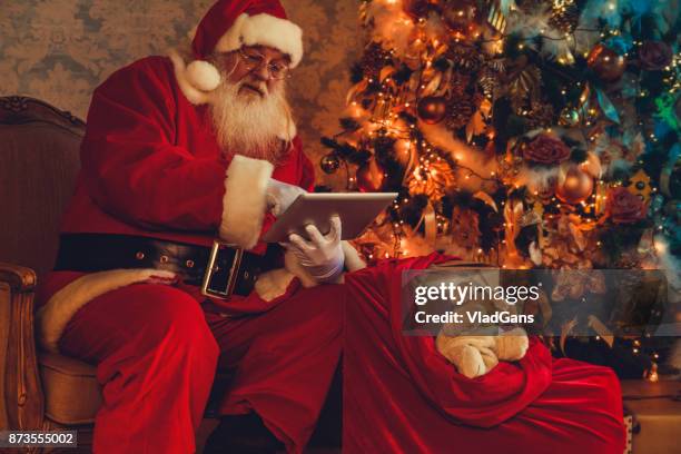 santa claus using digital tablets - santa claus desktop stock pictures, royalty-free photos & images