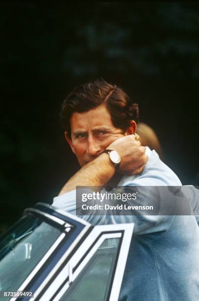 Prince Charles leans on his car at Cowdray Park Polo Club in Sussex on August 2, 1982