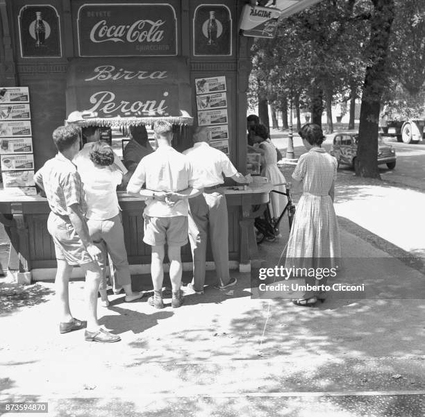 Thirsty people buying a drink at the kiosk in Rome in a very hot day, 1958.