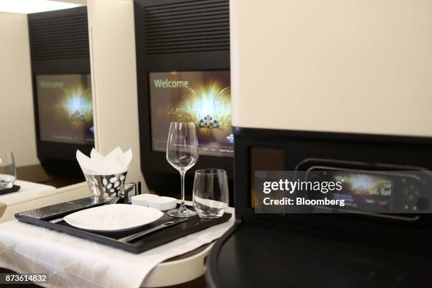 Wine glass and tableware sit inside the first class cabin of an Airbus SE A380 passenger aircraft, operated by Etihad Airways PJSC, during the 15th...