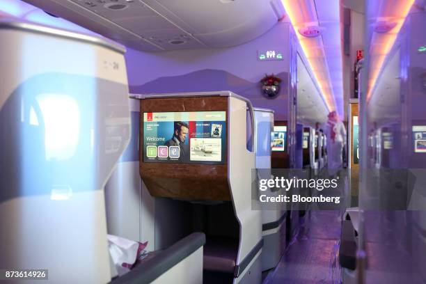 An in-flight entertainment screen sits on seating in the business class cabin of an Airbus SE A380-800 passenger aircraft, operated by Emirates...