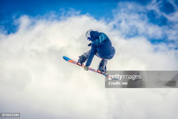 snowboarder in mid-air doing a melon grab - freestyle snowboarding stock pictures, royalty-free photos & images