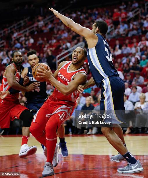 Eric Gordon of the Houston Rockets drives to the basket as Brandan Wright of the Memphis Grizzlies defends at Toyota Center on October 23, 2017 in...