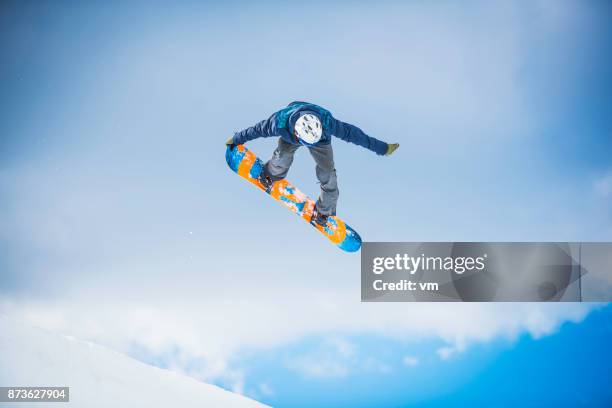 snowboarder performing a tail grab - freestyle snowboarding imagens e fotografias de stock