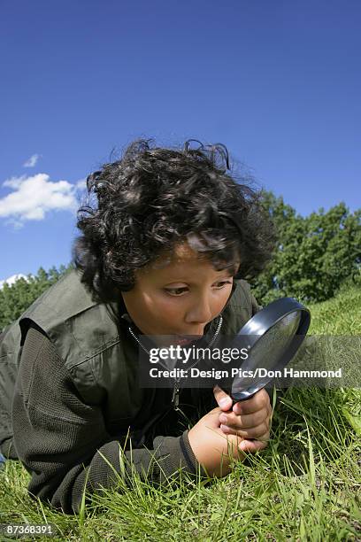 excited boy with magnifying glass - design pics don hammond stock-fotos und bilder