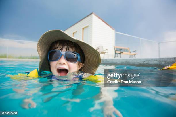 mixed race girl wearing sunglasses in swimming pool - kids swim caps stock pictures, royalty-free photos & images