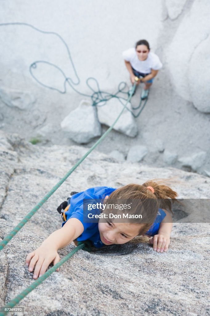 Asian mother and daughter rock climbing