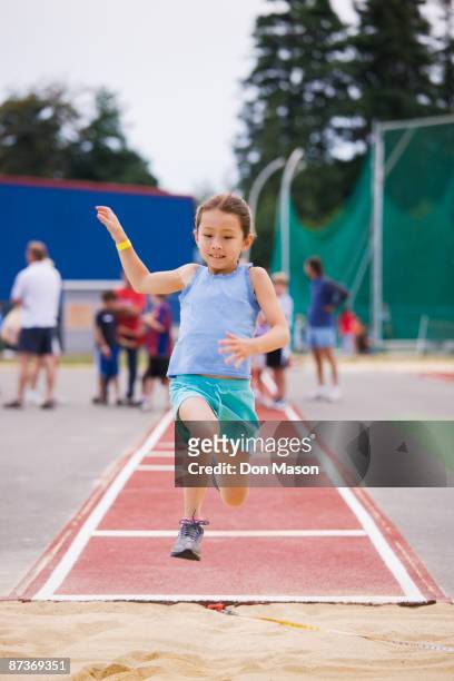 asian girl performing long jump - track and field event 個照片及圖片檔
