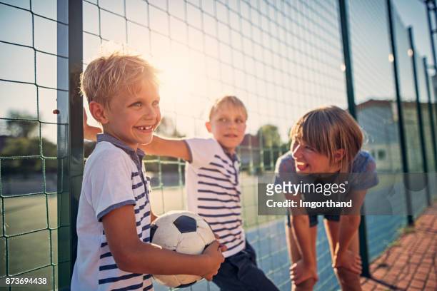 kindern beim spielen auf dem schulhof - football player stock-fotos und bilder