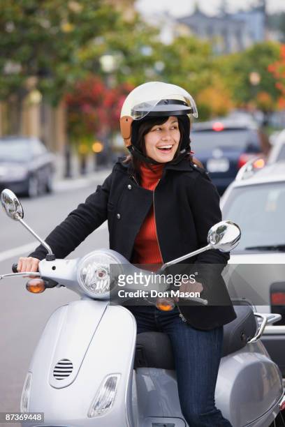 mixed race woman in helmet driving scooter - mujer feliz sola 30 35 fotografías e imágenes de stock