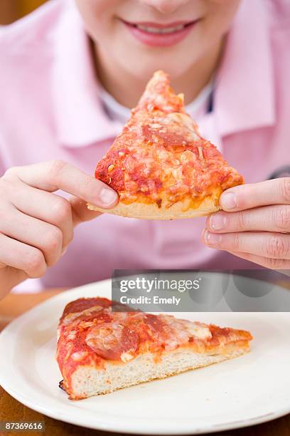 boy eating a piece of pizza - pepperoni pizza stock pictures, royalty-free photos & images