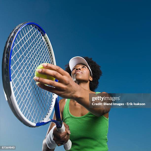 african woman playing tennis - serving sport stock-fotos und bilder