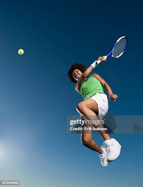 african woman playing tennis in mid-air - afro jokes stock-fotos und bilder