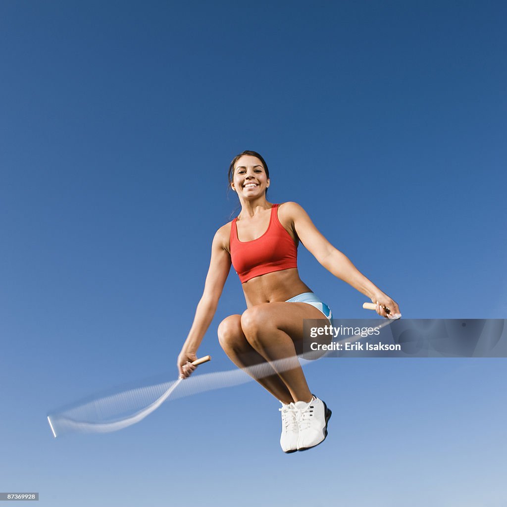 Native American woman jumping rope in mid-air