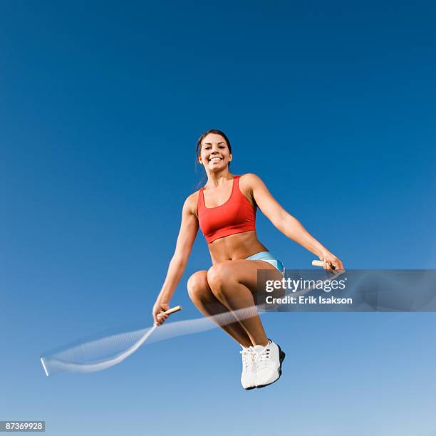 native american woman jumping rope in mid-air - woman skipping stock pictures, royalty-free photos & images