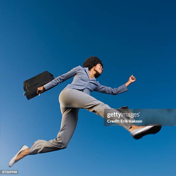 african businesswoman carrying briefcase in mid-air - business woman working late stock pictures, royalty-free photos & images