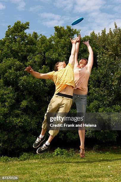 Couple Jumping To Catch A Frisbee, 照片檔