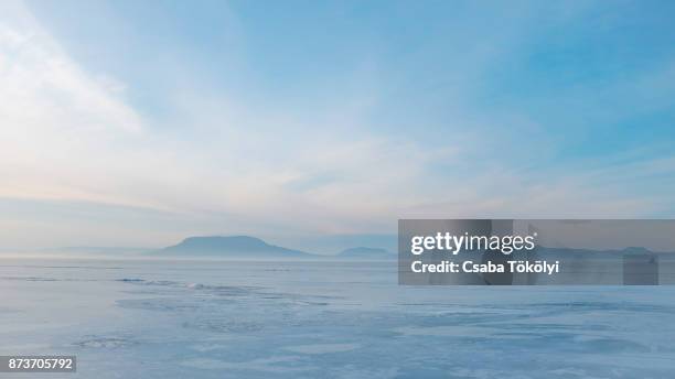 the frozen balaton with badacsony in the distance - ice sheet stock pictures, royalty-free photos & images