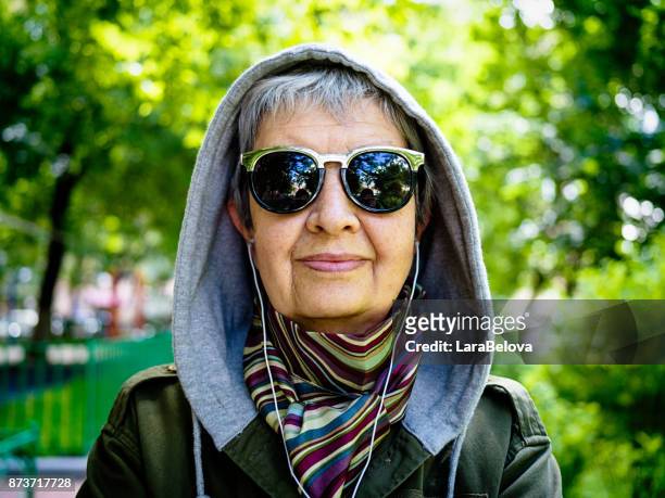 porträt der älteren frau in der haube - grey hair cool woman stock-fotos und bilder