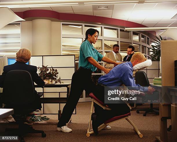 office worker getting chair massage - massagestuhl stock-fotos und bilder