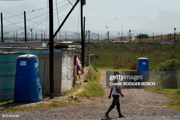 Man walks past portable toilets at an informal settlement in Khayelitsha, a mostly impoverished township, about 35km from the centre of Cape Town, on...