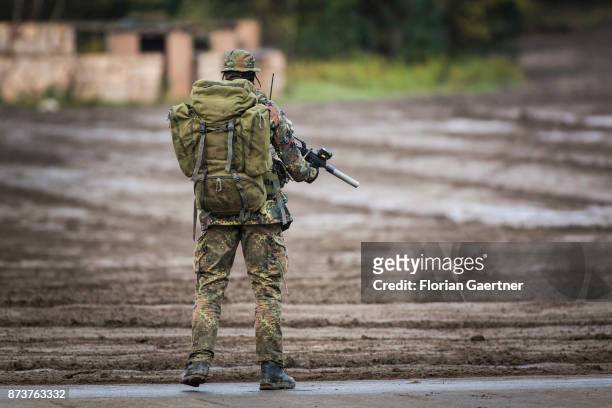 Masked soldier from the patrol with backpack and gun. Shot during an exercise of the land forces on October 13, 2017 in Munster, Germany.