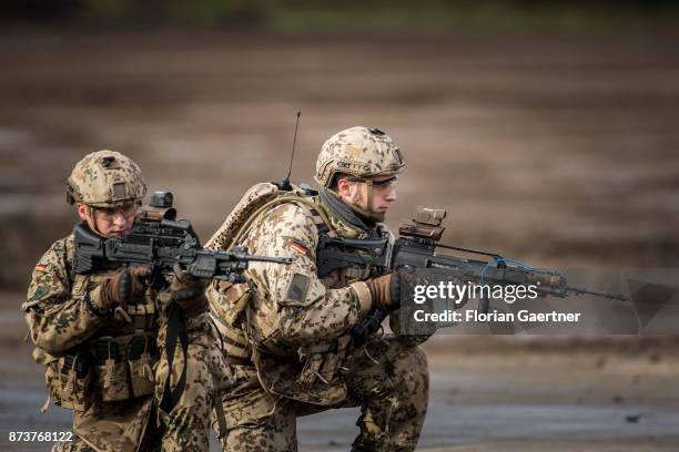 Two soldiers with equipment 'Infantryman of the Future - Extended System and ready to fire guns. Shot during an exercise of the land forces on...