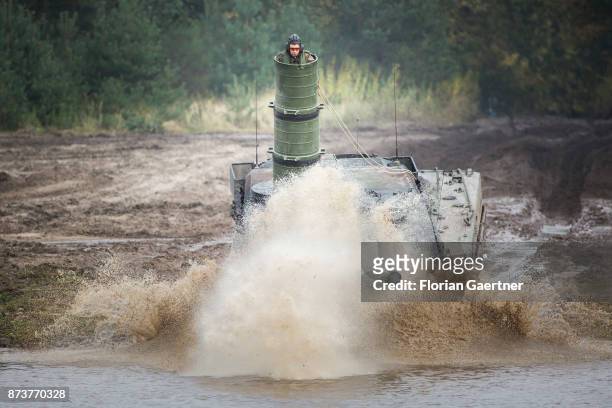 Main battle tank 'Leopard2' with attached diving shaft in which a soldier stands, drives into a moat. Shot during an exercise of the land forces on...