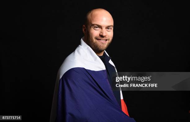 French skier David Poisson poses with the French national flag during the presentation ceremony of the French delegation to the Olympic Games in...