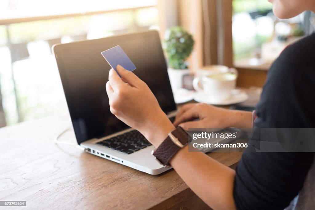 Selective focus hipster female hand  shopping & paying online market by smartphone with laptop computer