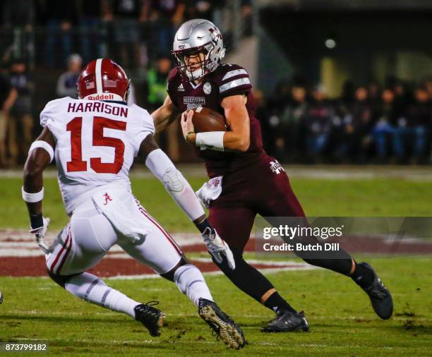 Nick Fitzgerald of the Mississippi State Bulldogs carries the ball as he tries to get around Ronnie Harrison of the Alabama Crimson Tide during the...