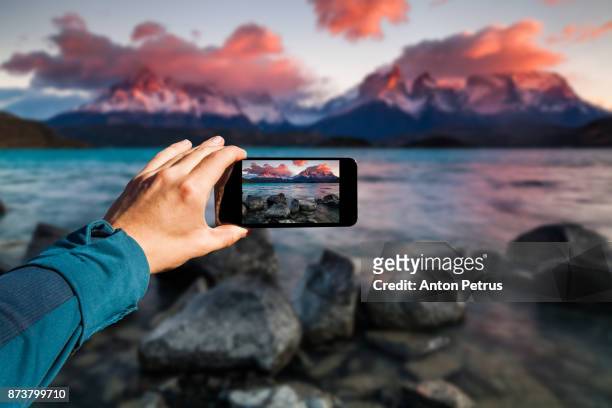 photographing with smartphone in hand. travel concept. torres del paine, chili - view at the camera stock pictures, royalty-free photos & images