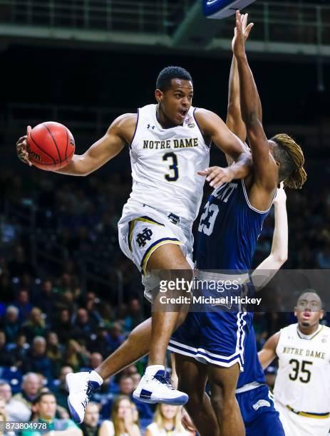 Harvey of the Notre Dame Fighting Irish passes the ball against Greg Alexander of the Mount St. Mary's Mountaineers defends at Purcell Pavilion on...