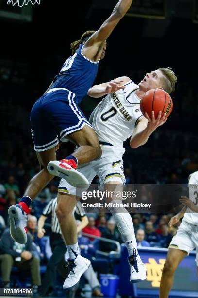 Rex Pflueger of the Notre Dame Fighting Iris shoots the ball against Greg Alexander of the Mount St. Mary's Mountaineers at Purcell Pavilion on...